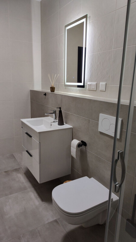 Das Badezimmer ist mit einem LED-Spiegel und einem Waschbecken ausgestattet